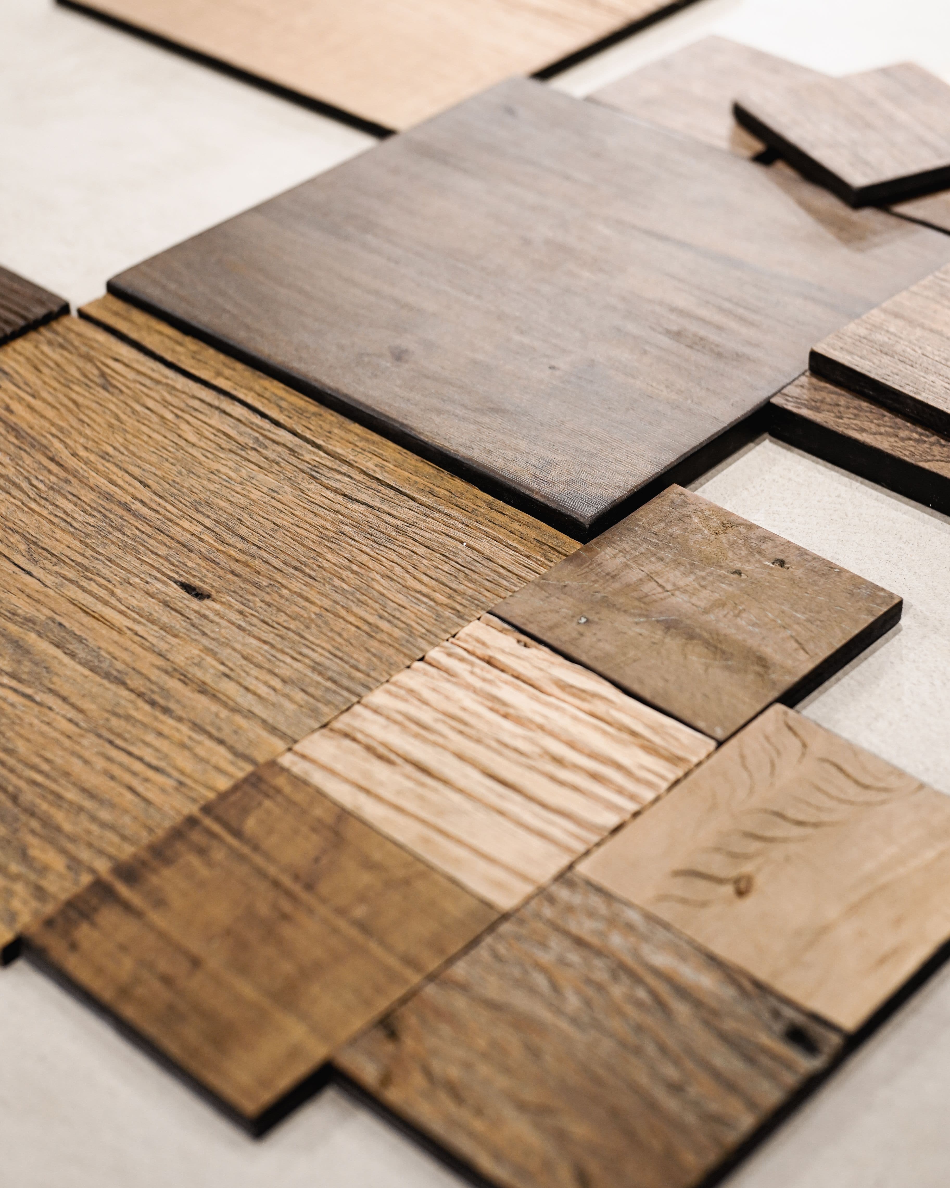 Stacked laminate and wood flooring swatches in a range of tones