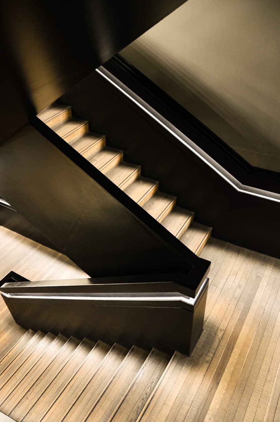 Timber staircase with dark treads against a white wall